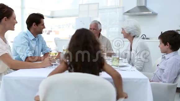 一家人坐在餐桌上品尝美食视频的预览图