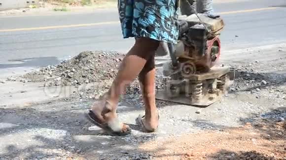泰国人在施工现场使用土壤压实机在农村道路上工作和修复路面视频的预览图