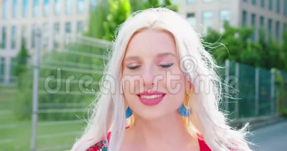 年轻的金发女郎微笑的户外视频的预览图