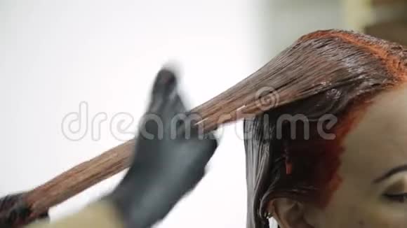 理发师为年轻女人做染发美发人的观念视频的预览图