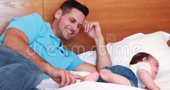 父亲在床上和他的小男孩玩耍视频的预览图