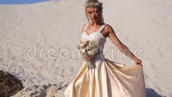 美丽的新娘穿着时尚的飞行服装和花环在迪拜的大沙漠视频的预览图