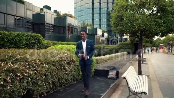 穿着蓝色西装走路的美国黑人商人视频的预览图