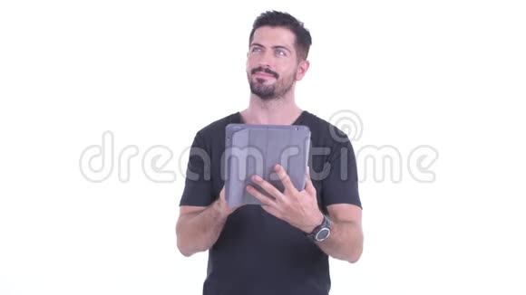 快乐的年轻英俊的胡须男用数码平板电脑思考视频的预览图