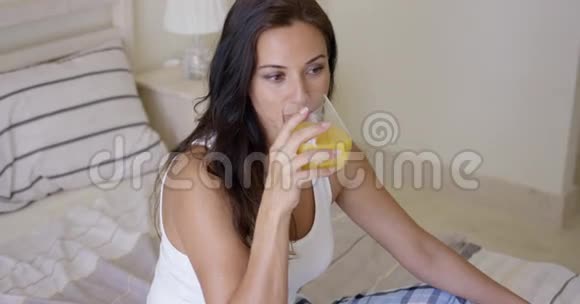 年轻女子喝着一杯橙汁视频的预览图