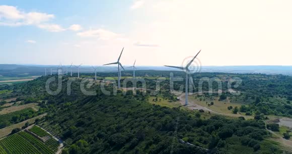 一座山上有田和藤蔓的风力涡轮机视频的预览图