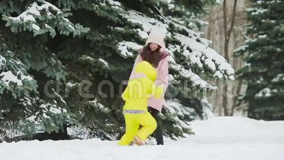 快乐的母亲和孩子享受冬天的雪日视频的预览图