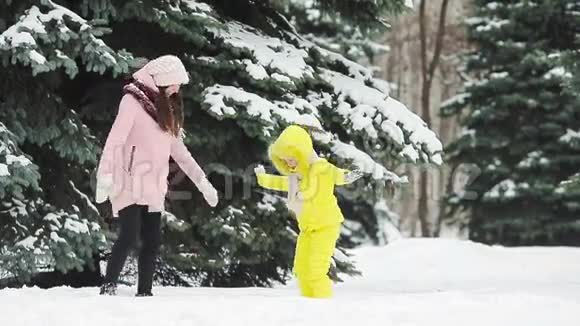 母亲和女儿的家人享受冬天的雪日和打雪球视频的预览图