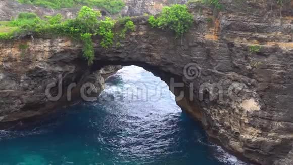 海上和岩石的空中景色从顶部看绿松石水背景夏天从空气中渗出努萨克林金海滩视频的预览图