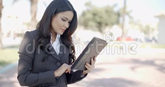 女商人在街上用平板电脑工作视频的预览图