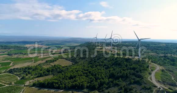 一座山上有田和藤蔓的风力涡轮机视频的预览图