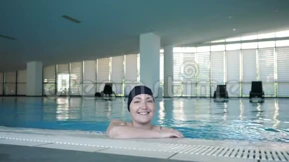 游泳池里戴帽子的年轻女子视频的预览图