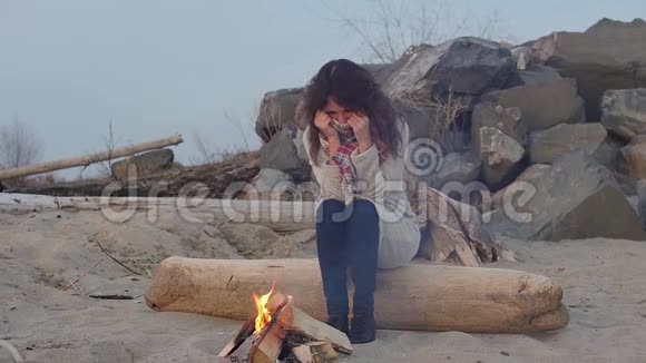 晚上坐在火炉旁的年轻女子开火视频的预览图