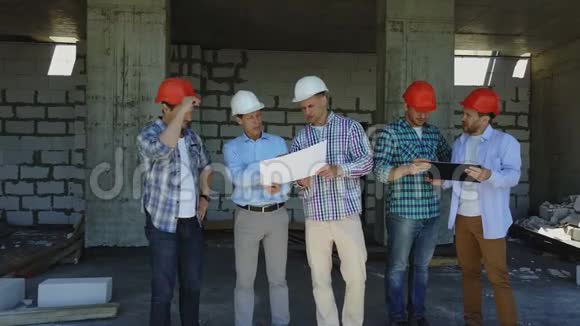 建筑施工队伍在施工现场的航拍镜头与建筑师和承包商讨论项目计划视频的预览图
