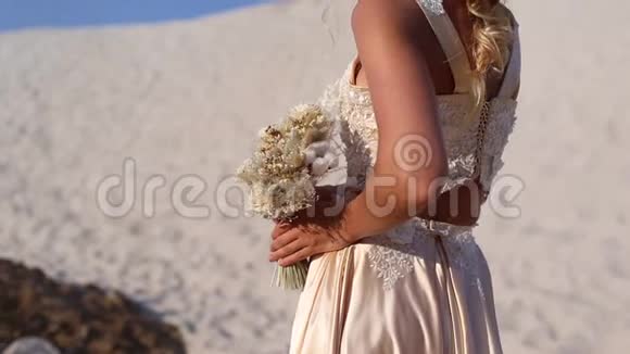 美丽的新娘穿着时尚的飞行服装和花环在迪拜的大沙漠视频的预览图