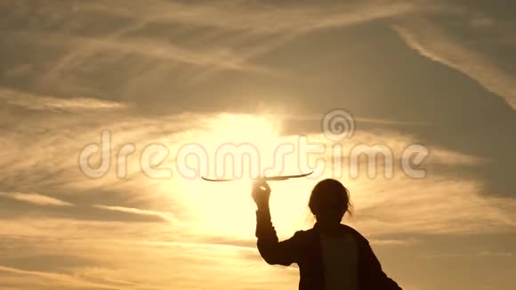 飞行的梦想孩子们在太阳的背景下手里拿着一架飞机儿童在飞机上玩耍的剪影视频的预览图