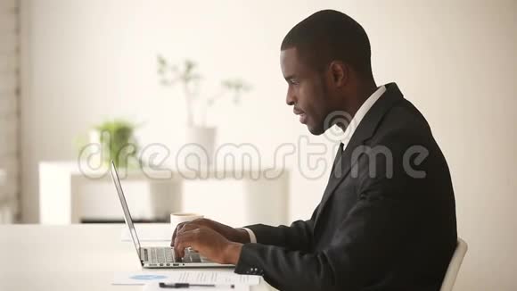 办公桌上坐着电脑的非裔美国商人视频的预览图