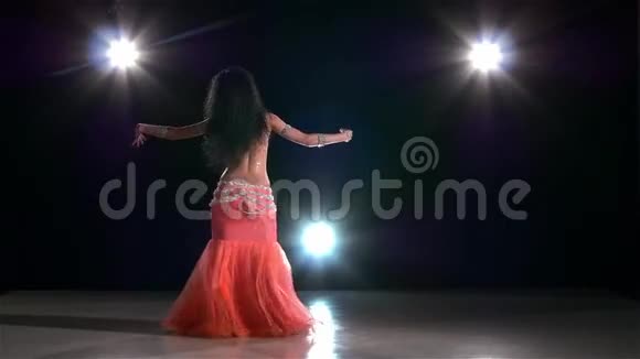 年轻的肚皮舞女在黑色上跳舞视频的预览图