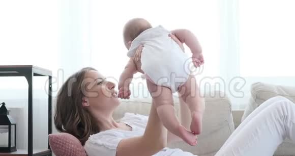 年轻的母亲在家里和她的女婴玩耍视频的预览图