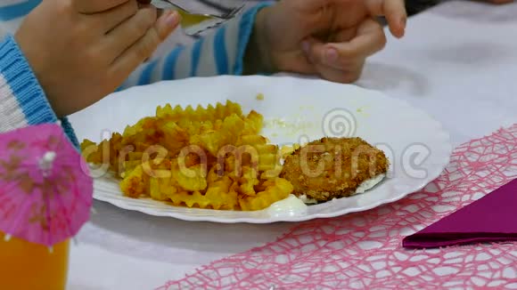 青少年在餐馆里吃炸薯条土豆和牛排盘子视频的预览图