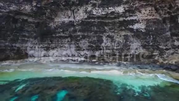 海上和岩石的空中景色从顶部看绿松石水背景夏天从空气中渗出努萨克林金海滩视频的预览图