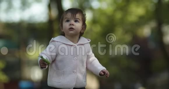 可爱的女婴在春末探索公园视频的预览图