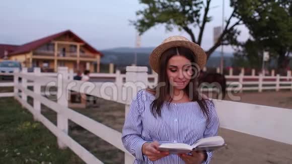 美丽的孕妇在农场读这本书她站在一旁看着书放松放松视频的预览图