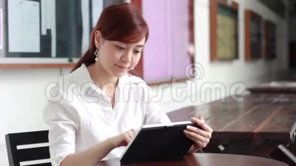 泰国成年女商人漂亮女孩用平板电脑视频的预览图