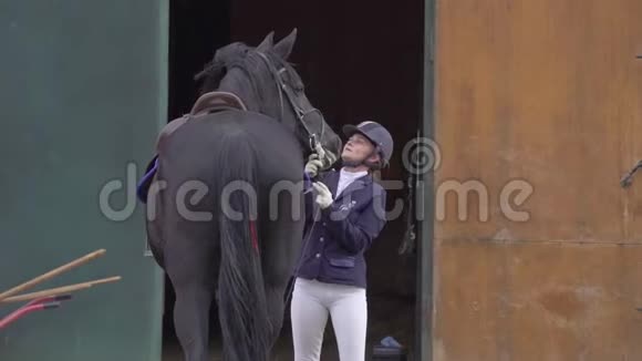 一个穿着黑白西装骑师的年轻女骑手与她心爱的马交流视频的预览图