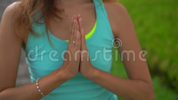 一位年轻女子在美丽的稻田里练习瑜伽的慢镜头视频的预览图