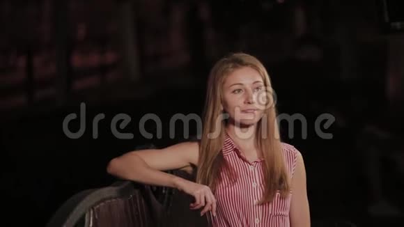 晚上在公园里的长椅上漂亮的年轻女孩视频的预览图