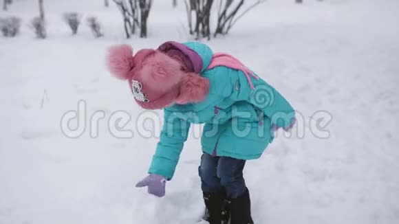 女孩在冬天的雪地里雕刻雪人视频的预览图