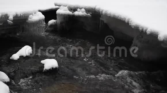 在公园里流着雪的水动作缓慢背景中的冰柱视频的预览图