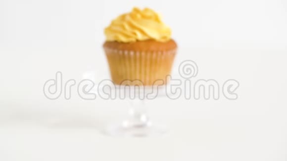 玻璃桌上有黄色霜冻的纸杯蛋糕视频的预览图