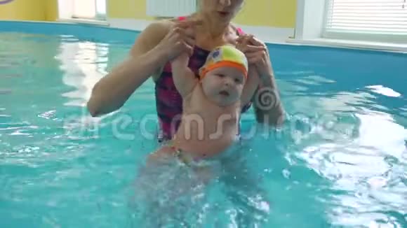 游泳教练与可爱的婴儿在游泳池视频的预览图