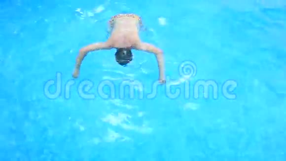 一个人在有蓝色水的游泳池里在水下游泳从上面看视频的预览图