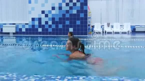 快乐的年轻女子在游泳池游泳视频的预览图