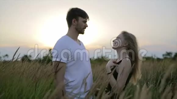 日落的浪漫情侣两个人在日落或日出时相爱男人和女人在野外接吻视频的预览图