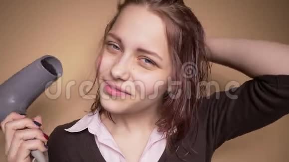 情绪快乐的少年女孩一边晒头发一边做滑稽的脸慢动作视频的预览图