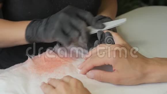 美容师在美甲沙龙中将指甲油涂在女性指甲上的特写镜头女性指甲修剪水疗视频的预览图