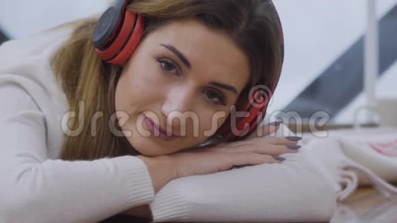 年轻的金发女郎戴着耳机听音乐视频的预览图