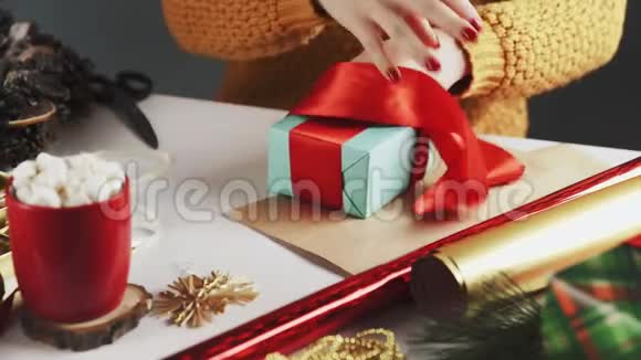 在圣诞礼物上系红丝带的女人视频的预览图