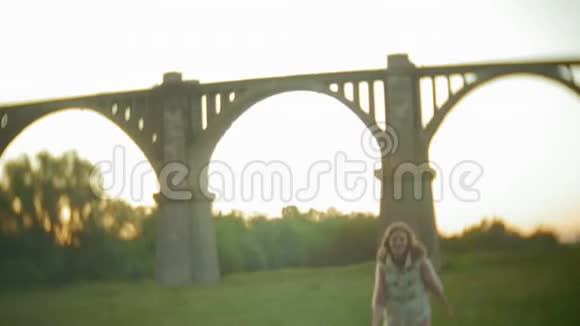 年轻女子正走在老式铁路桥附近视频的预览图