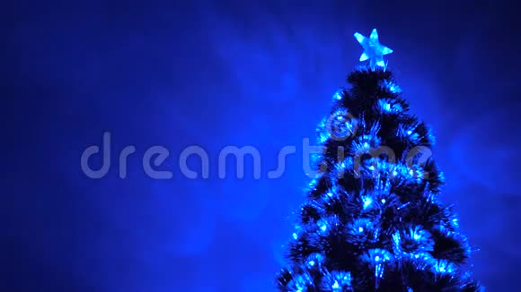 房间里有一棵漂亮的圣诞树装饰着一个发光的花环和一颗星星儿童和成人假期新视频的预览图