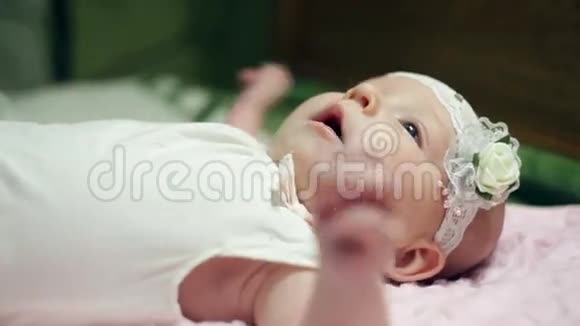 快乐的女婴躺在粉红色的毯子上视频的预览图
