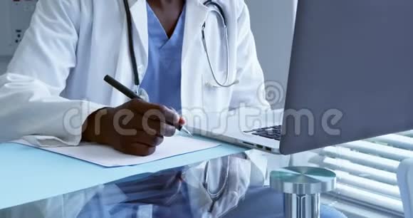 男医生在医院的办公桌上工作视频的预览图