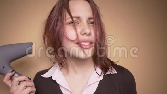 情绪快乐的少年女孩一边晒头发一边做滑稽的脸慢动作视频的预览图