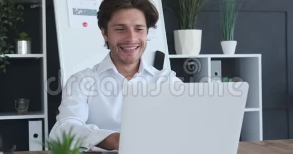 在笔记本电脑上工作的快乐商人视频的预览图