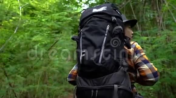徒步旅行者背着背包行走寻找天然森林视频的预览图