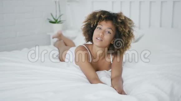 在床上摆姿势的模特视频的预览图